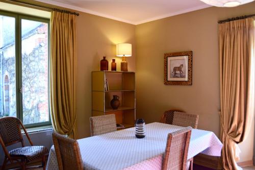 une salle à manger avec une table et des chaises et une fenêtre dans l'établissement Cottages de Château de Vaux, à Yvré-lʼÉvêque