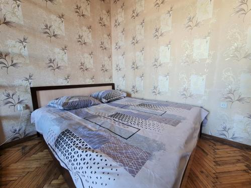 a large bed in a room with a wall at Apartments on Lenina in Mogilev
