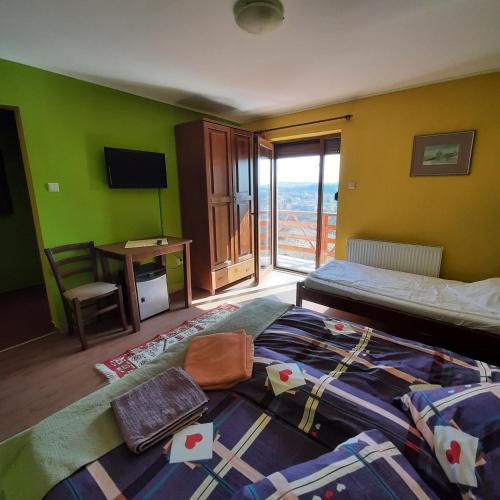 a bedroom with a bed and a desk with a window at Panorama Cehu Silvaniei in Cehu Silvaniei