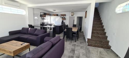 a living room with a purple couch and a kitchen at Oura - Large Villa - Private Pool - 5 Bedrooms in Albufeira