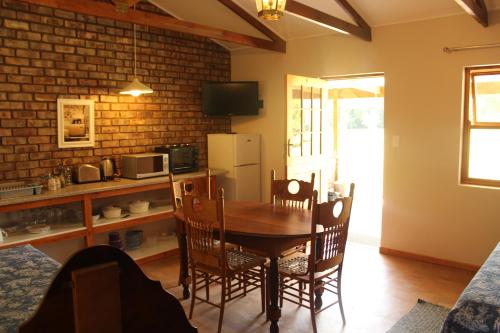 a kitchen and dining room with a table and chairs at Lentelus Guesthouse in George