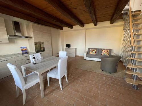 Una cocina y un comedor con mesa y sillas. en conGusto Apartments, en Cherasco