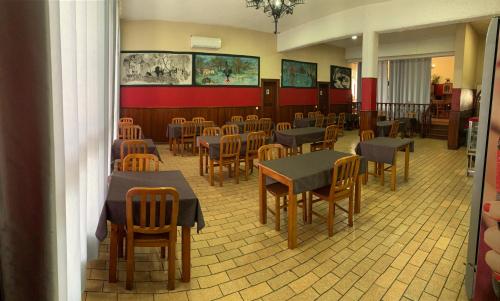 un ristorante con tavoli e sedie in una stanza di Kualquer Koisa a Tondela
