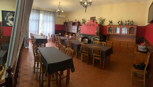 un ristorante con tavoli e sedie in una stanza di Kualquer Koisa a Tondela