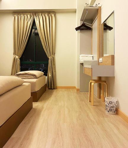 a room with two beds and a desk and a window at Amadel Residence 爱媄德民宿 16 in Melaka
