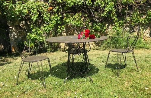 a table and two chairs in the grass at Chateau de Vaux in Yvré-lʼÉvêque