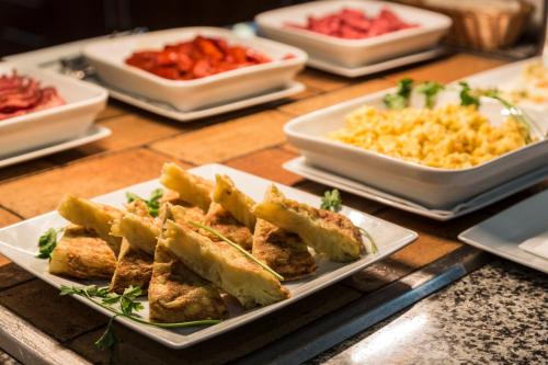 a table with plates of food and bowls of food at Abba Xalet Suites Hotel in Sispony