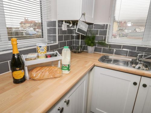 a kitchen counter with bottles of wine and bread on it at 31 Lloyd Street West in Llandudno