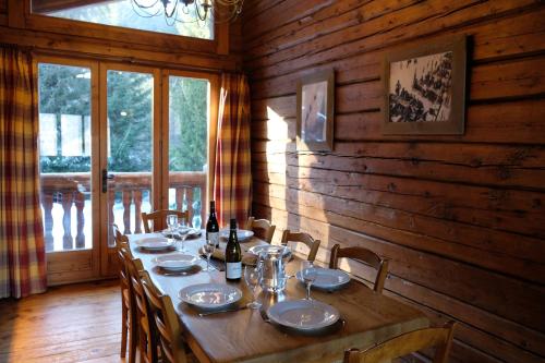 une salle à manger en bois avec une grande table et des chaises dans l'établissement Madame Vacances Chalet Elliot Est, à La Perrière
