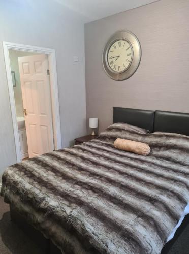 1 dormitorio con 1 cama grande y reloj en la pared en The Buck Inn, en Whitby