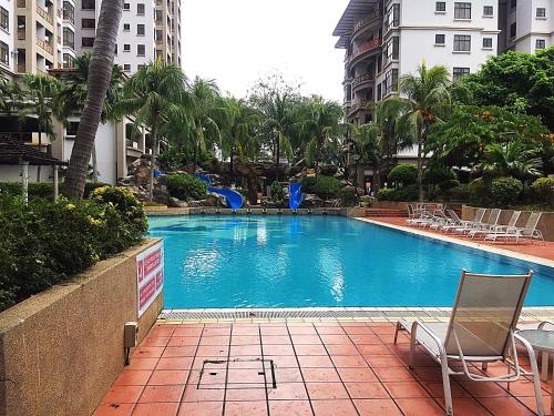 a swimming pool with chairs and trees and buildings at Amadel Residence 爱媄德民宿 16 in Melaka