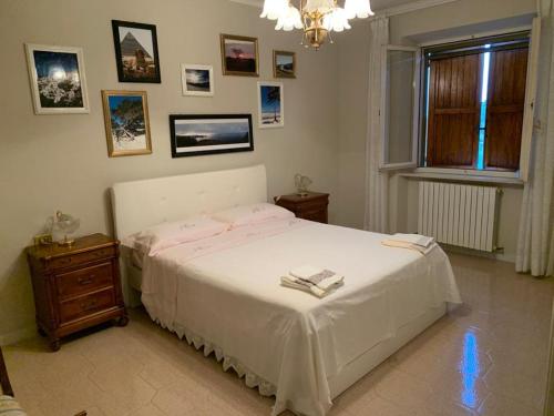1 dormitorio con cama blanca y ventana en Ai due Camini, en Cingoli