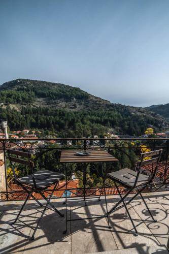 two chairs and a table on a balcony with a mountain at Proselinos in Dhimitsana