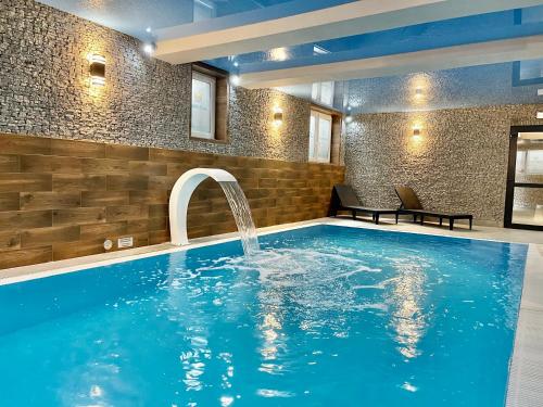 a swimming pool with a water fountain in a house at Baltic Sun SPA in Rewal