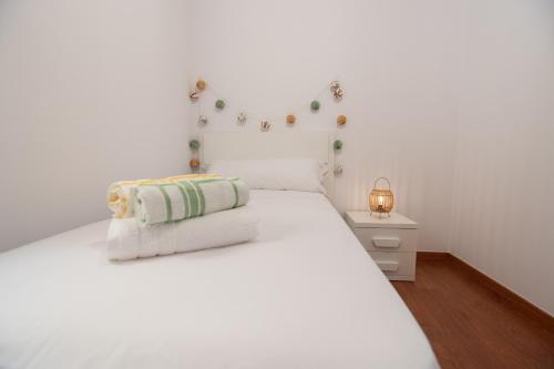 ein weißes Schlafzimmer mit einem weißen Bett und einer Lampe in der Unterkunft Attic Deltarelax in Deltebre
