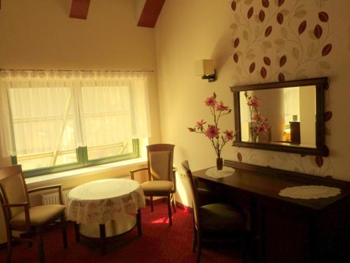a room with a table and chairs and a mirror at Apartamenty przy Głównym Deptaku in Wisła