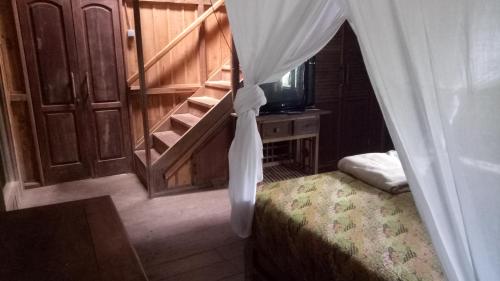 ein Schlafzimmer mit einem Bett mit einem Vorhang darüber in der Unterkunft Orangutan Bungalow in Bukit Lawang
