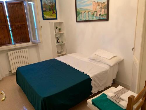 1 dormitorio con 1 cama y 1 silla en Ai due Camini, en Cingoli