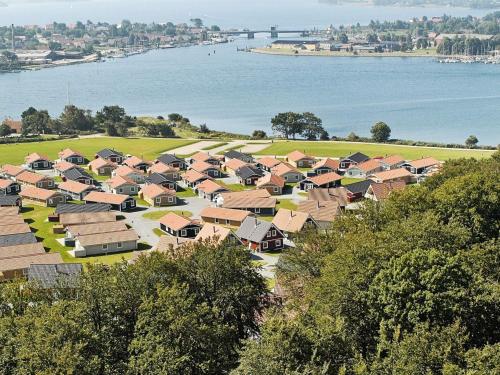 a group of houses in a field next to the water at 6 person holiday home on a holiday park in Gr sten in Gråsten