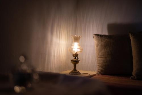 a lamp sitting on a table next to a bed at Proselinos in Dhimitsana