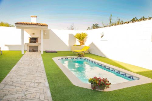 a swimming pool in the yard of a house at CASA LAS PALMERAS in Cambados