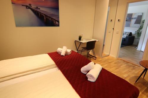 1 dormitorio con 1 cama con 2 toallas en City HotelApartment, en Karlshamn