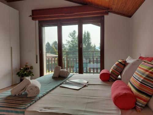 ein großes Bett in einem Zimmer mit einem großen Fenster in der Unterkunft Bnbook Casa dei Peschi - Lago di Monate in Cadrezzate