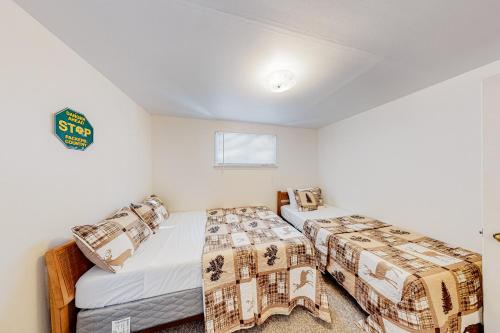 two beds in a room with white walls at Voyagers Cabin in Eagle River