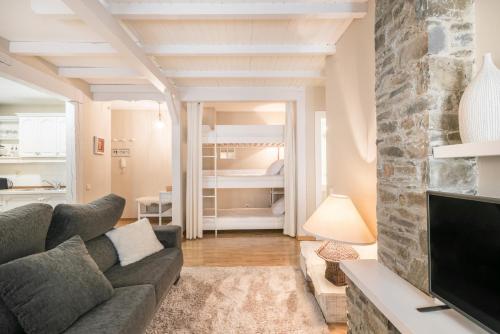 Una sala de estar con un sofá y un televisor. en Eli by Totiaran, en Naut Aran (Alto Arán)