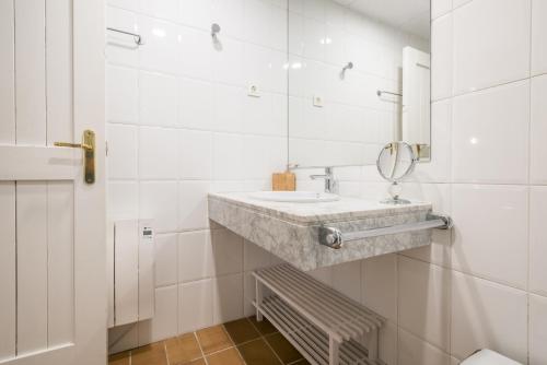 Un baño blanco con lavabo y espejo. en Eli by Totiaran, en Naut Aran (Alto Arán)