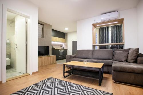 uma sala de estar com um sofá e uma mesa de centro em Apartment Ivy em Belgrado