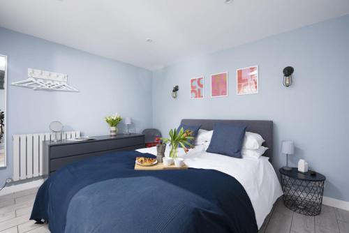 ein Schlafzimmer mit einem großen Bett mit einer blauen Decke in der Unterkunft Mousehole View in Mousehole
