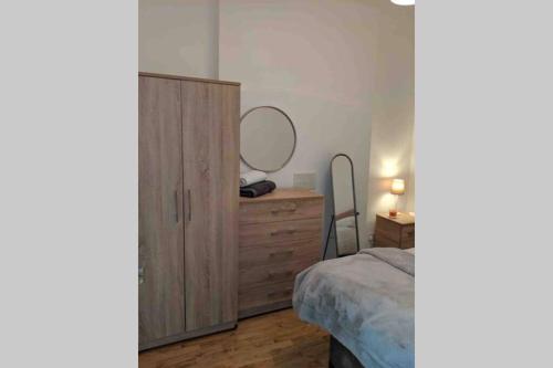 a bedroom with a dresser and a large mirror at Hidden Gem in the Bay 10 Mins from WMC in Cardiff