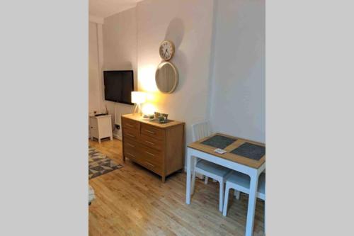 a room with a desk and a table and a television at Comfy Cardiff Bay Budget Stay with Small Garden 15 mins Walk to Cardiff Bay in Cardiff