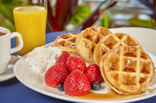 a plate of waffles and strawberries on a table at Holiday Inn Resort Panama City Beach, an IHG Hotel in Panama City Beach