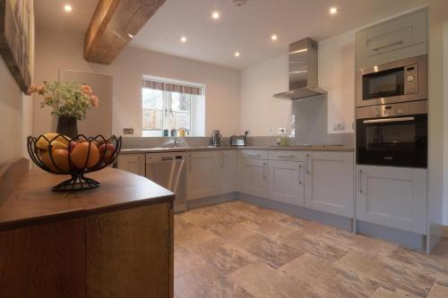 a kitchen with white cabinets and a counter top at The Tack Room - Perfect for Two in Redlynch
