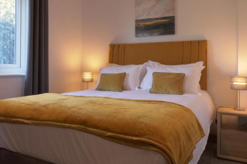 a bedroom with a large bed with two pillows at The Tack Room - Perfect for Two in Redlynch