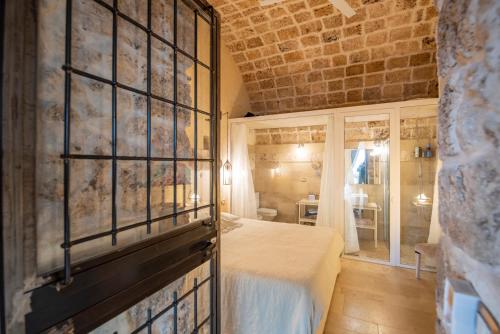 a bedroom with a bed and a brick wall at Villa Il Carrubo val di noto con piscina privata in Avola