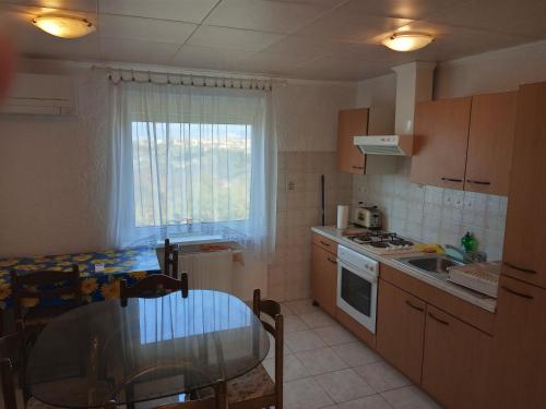 a small kitchen with a table and a glass table at ANKARAN SOBE MARA in Ankaran
