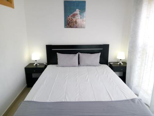 クアルテイラにあるDunas 3- Elegante, 150mt Praia, Wifiのベッドルーム1室(白い大型ベッド1台、ナイトスタンド2台付)