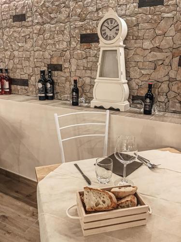 ein Tisch mit einem Tablett mit Brot und einer Uhr in der Unterkunft Lo Sciatore Hotel & Restaurant in Camigliatello Silano