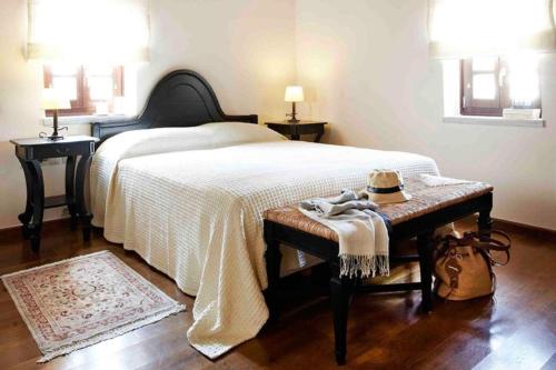 a bedroom with a bed with a hat on a bench at Petritis Guesthouse in Oítilon
