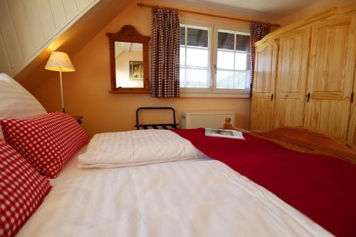 - une chambre avec un grand lit blanc et des oreillers rouges dans l'établissement Landhaus-Vintage Fe-Wo-Apartment 5, à Schluchsee