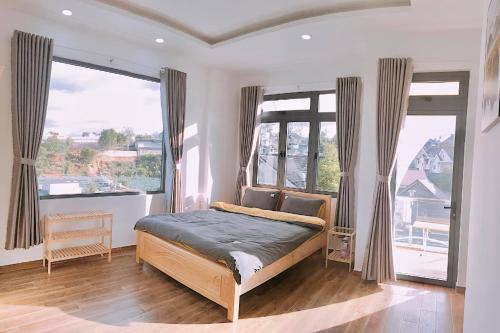 Homestay M-Latino Dalat في Da Thien: غرفة نوم مع سرير في غرفة مع نوافذ