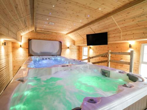a large hot tub in a wooden room at Tynewydd Fields in Lampeter