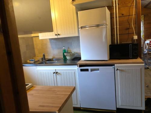 a kitchen with a white refrigerator and a sink at Holiday House with beautiful scenery near Göta Kanal in Undenäs
