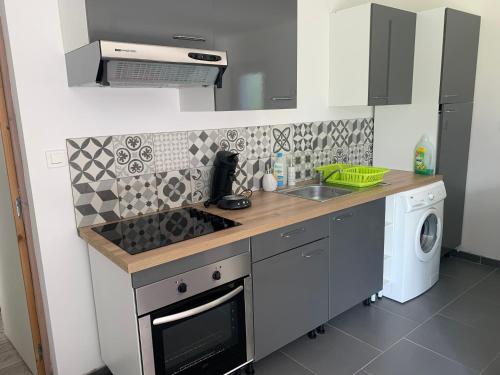 une cuisine avec un évier et une cuisinière four supérieur dans l'établissement LE GITE COTE D OPALE, à Calais