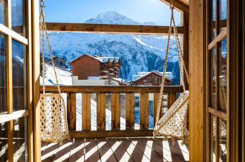 a porch swing with a view of a mountain at Black Diamond Sainte Foy Chalets in Sainte-Foy-Tarentaise