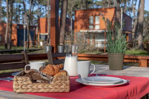 a picnic table with a basket of bread and milk at Bungalow B9 - Nature, Beach & River in Fão