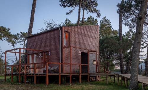 a small cabin in the woods with a tree at Bungalow B9 - Nature, Beach & River in Fão